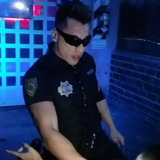 Pablo caracterizado de policía, con gafas de sol, bajo luz azul de sala.